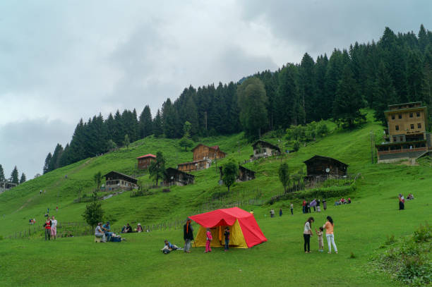 a group of people on a hill with a tent